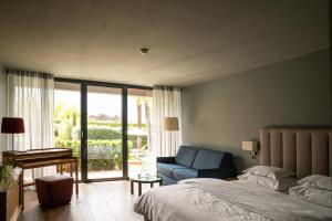 梅拉诺穆彻勒酒店的卧室配有床、椅子和窗户。