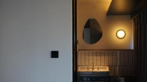 长沙in between彼厅酒店的浴室设有水槽和墙上的镜子