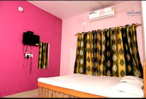 Nirmalsea land lodging & restaurant的一间设有床铺和粉红色墙壁的客房