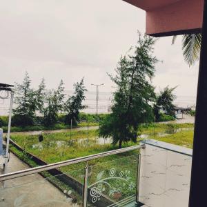 Nirmalsea land lodging & restaurant的享有草地景致的阳台