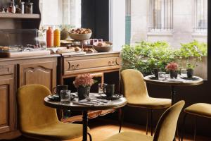巴黎Albert's Hotel的厨房配有2张桌子和椅子以及炉灶。