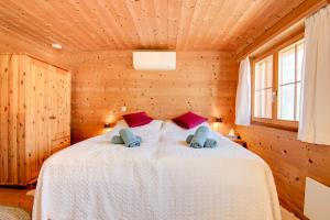 KüblisGemütliches Chalet mit schöner Aussicht的木制客房内的一间卧室,配有一张床