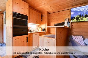 KüblisGemütliches Chalet mit schöner Aussicht的小屋内的厨房设有木制橱柜和电视。