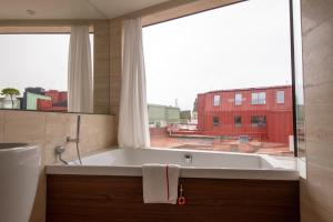 哥德堡阿瓦隆酒店的带浴缸的浴室和大窗户