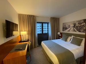 安道尔城泽尼特外交酒店的酒店客房设有一张大床和一台电视。