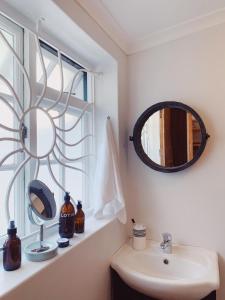 开普敦Cottage On Windsor的浴室设有水槽和窗户上的镜子
