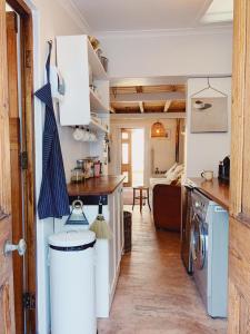 开普敦Cottage On Windsor的厨房以及带洗衣机和烘干机的客厅。