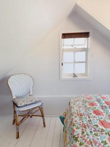开普敦Cottage On Windsor的卧室配有一张床和一把椅子,靠窗