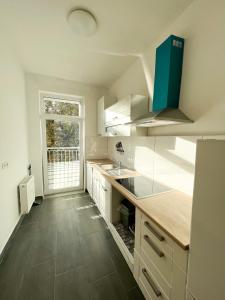 莱比锡517 Zentrum Ost Apartment的一间厨房,配有白色的橱柜和大窗户