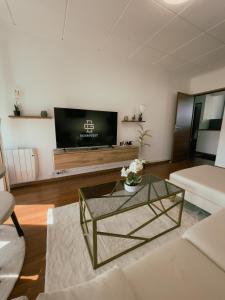 Soisy-sous-MontmorencyAppartement Cosy & Connecté à 15 min de Paris的客厅配有咖啡桌和电视