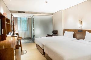 广州客村喆啡酒店(广州塔琶洲会展店)的酒店客房配有两张床和一张书桌