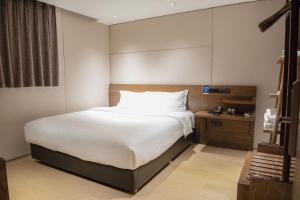 广州客村喆啡酒店(广州塔琶洲会展店)的卧室配有一张白色大床