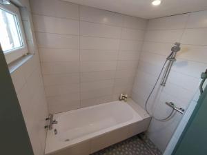 维尔纽斯Hillside country house - Long stays的白色的浴室设有浴缸和淋浴。