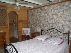 PriayChez Jean Marc et Corinne的一间卧室设有一张床和石墙