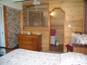 PriayChez Jean Marc et Corinne的一间卧室设有一张床和木墙