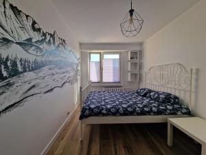 新塔尔格Apartament na wynajem的卧室配有一张床,墙上挂有绘画作品