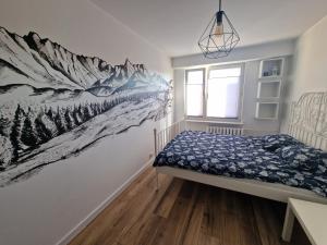 新塔尔格Apartament na wynajem的卧室的墙上挂着雪白的山壁画