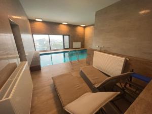 布尔诺AZ Tower Apartment的客厅设有游泳池、桌子和椅子