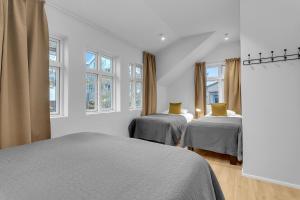 雷克雅未克Capital Luxury Apartments的一间白色卧室,配有两张床和窗户