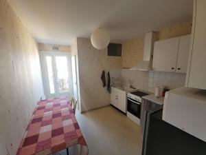 贝尔热拉克Appartement centre-ville de Bergerac 4 personnes的一间小厨房,配有白色的橱柜和一张桌子