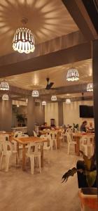 图杜Rihiveli Residence Thoddoo的餐厅设有桌子、白色椅子和吊灯