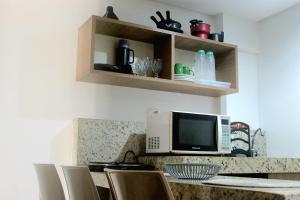若昂佩索阿Imperial Flat Tambaú 311的厨房配有带微波炉和椅子的柜台