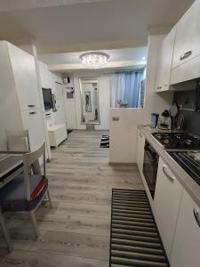 普拉托La Casina Pallacorda的厨房配有白色橱柜,地板铺有木地板。
