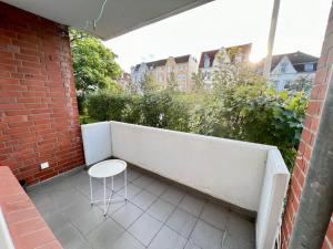基尔Work&Stay Apartment - Kiel的白色凳子坐在带砖墙的阳台上