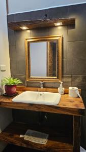 危地马拉Lindo LOFT VIP a 5 minutos de Cayala的浴室水槽和木台面上的镜子