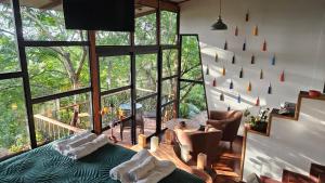 危地马拉Lindo LOFT VIP a 5 minutos de Cayala的客房设有床、椅子和大窗户。