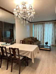 曼谷OV Residence的客厅配有桌子和吊灯