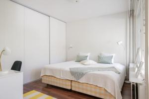 于韦斯屈莱Kaksio yliopiston vieressä的卧室配有一张带白色墙壁的大床