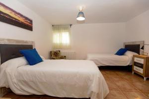 托雷斯Casa Jurinea Alzar的一间卧室配有两张带蓝色枕头的床