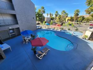 萨克拉门托Motel 6 Sacramento CA Natomas的一个带两把遮阳伞和椅子的大型游泳池