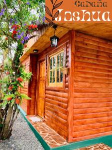 伊瓜苏港Cabaña Joshua的一座带门和鲜花的小木结构建筑