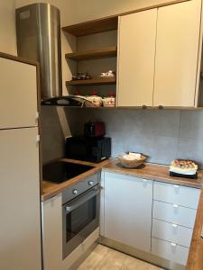 贝尔格莱德Apartment ON TOP 23的厨房配有白色橱柜和炉灶烤箱。