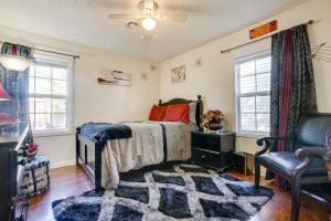 马里恩Cozy Indiana Home with Deck, Charcoal Grill and Yard!的一间卧室配有一张床、一把椅子和窗户。