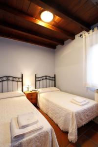 坎德拉里奥Casa Rural Puerta del Sol II de 2 habitaciones的一间卧室设有两张床和窗户。