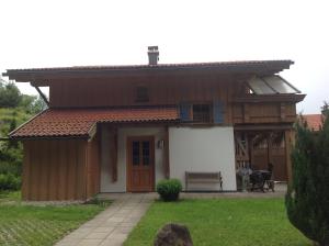 SachrangFerienhaus Sachrang的前面有长凳的房子