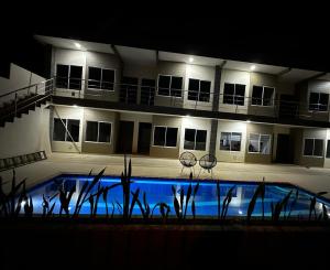 莱蒂西亚Apartamentos Sin fronteras的一座晚上设有游泳池的建筑