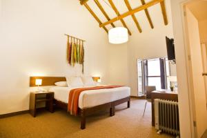 库斯科提阿瓦非凡库斯科中心酒店的一间卧室配有一张床和一台电视
