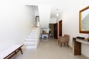 库亚巴HOSTEL DIKASA的白色走廊设有楼梯和镜子