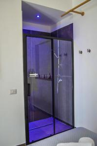 埃尔科拉诺Scavi 32的浴室设有玻璃淋浴间,拥有紫色的灯光