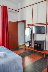 埃尔科拉诺Scavi 32的一间设有床、镜子和红色窗帘的房间