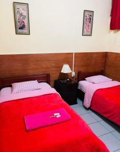 利马KORICANCHA的一间设有两张红色毯子的床的房间
