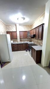 瓦迪穆萨Sara apartment的空厨房配有木制橱柜和冰箱