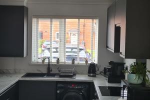 曼彻斯特Runway Airbnb的厨房配有水槽、洗碗机和窗户。