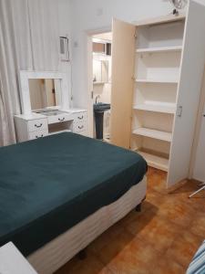 瓜鲁雅Aconchego的一间卧室配有床、镜子和书架