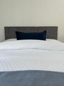 穆林加尔A Village Gem的一张白色的床,上面有蓝色的枕头