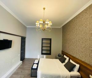 第比利斯2nd Floor Hotel的一间卧室配有一张床和一个吊灯